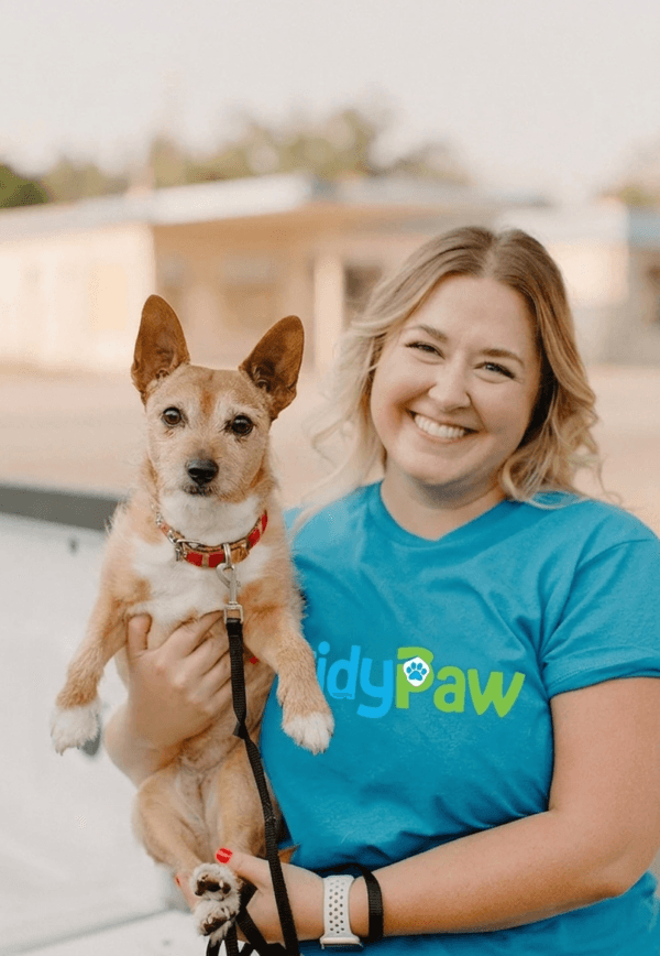 TidyPaw team member holding a happy dog